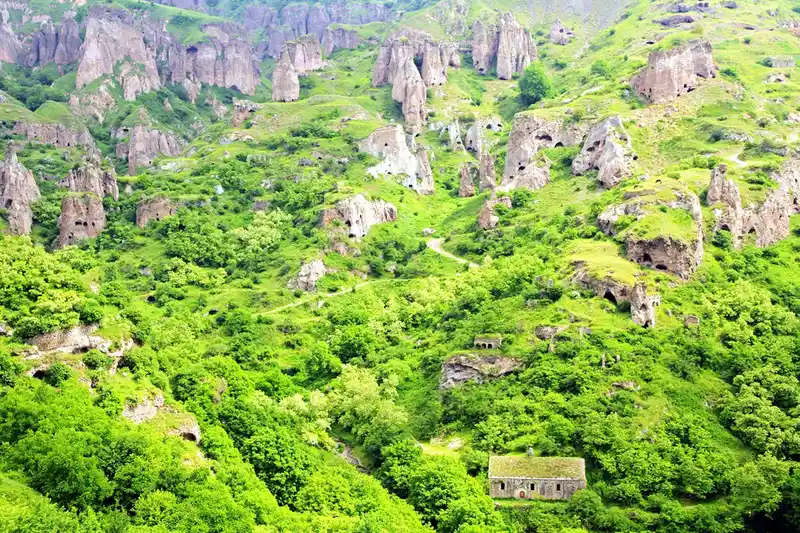 تصویری از خانههای غاری روستای خندزورسک در درهای سرسبز