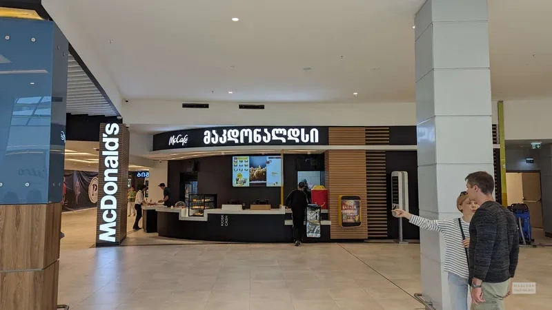 شعبه مک دونالد باتومی در مرکز خرید گرند مال هم فال است و هم تماشا. با مراجعه به این شعبه میتوانید در مرکز خرید گشت و گذار کنید و بعد از خرید، خود را مهمان یک وعده غذای خوشمزه و عالی بفرمایید. در نزدیکی این مرکز خرید، دیدنیها و مراکز تفریحی متنوع دیگری مانند پارک آبی هم وجود دارد.