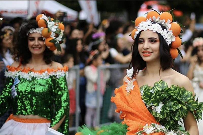 صویری از 2 دختر جوان که برای جشنواره شکوفه پرتقال آلانیا، لباس های نمادی با تزیین پرتقال پوشیدهاند