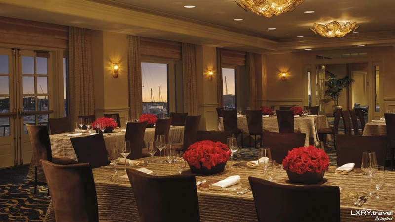 فضای داخلی رستوران هتل ۵ ستاره ریتز کارلتون استانبول، با میزهای چیده&zwnj;شده برای شام، گل&zwnj;های رز قرمز و نورپردازی گرم داخلی.&nbsp;