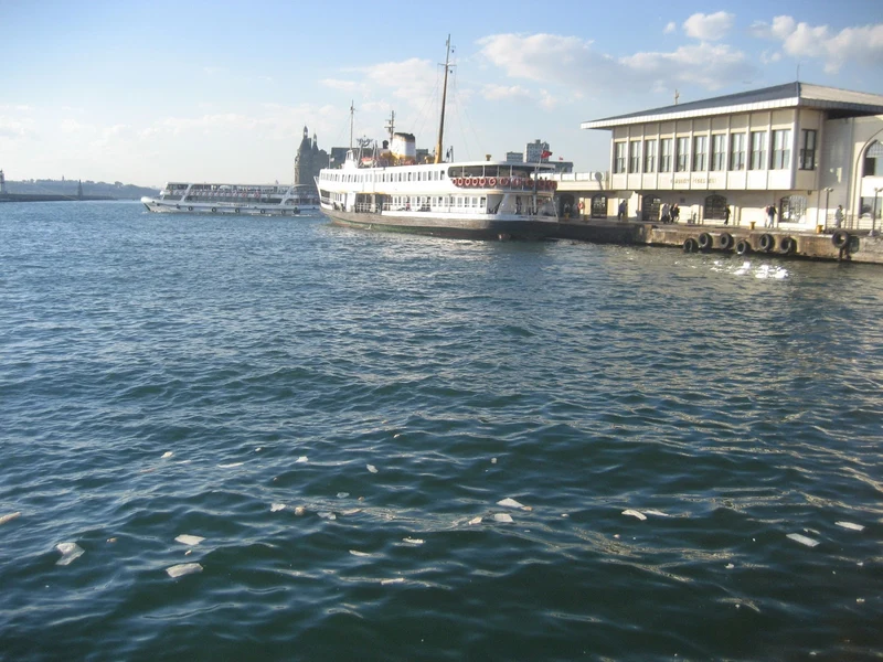  نمایی از اسکله کادیکوی استانبول با یک کشتی شهری (Vapur) پهلو گرفته و ایستگاه تاریخی حیدرپاشا در پس&zwnj;زمینه، نقطه شروع گشت&zwnj;وگذار در کادیکوی.