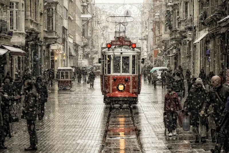  تراموای نوستالژیک قرمز در خیابان استقلال استانبول در یک روز برفی میان عابرین پیاده