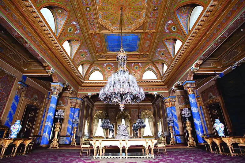 تالار مجلل آبی در داخل کاخ بیلربیی، با ستون&zwnj;های بزرگ آبی، لوستر کریستال و سقفی طلاکاری شده