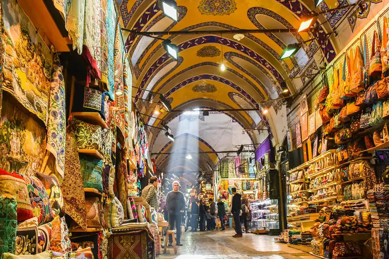 فضای داخلی بازار بزرگ استانبول با سقف&zwnj;های قوسی و نقاشی&zwnj;شده، و مغازه&zwnj;های فروش صنایع دستی رنگارنگ
