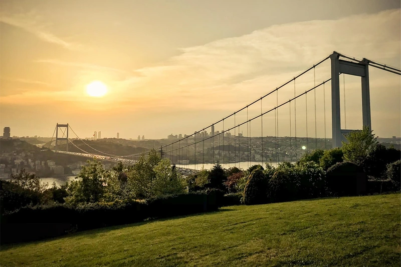 منظرۀ پل بسفر استانبول در ساعت طلایی (قبل از غروب) از یک پارک سرسبز