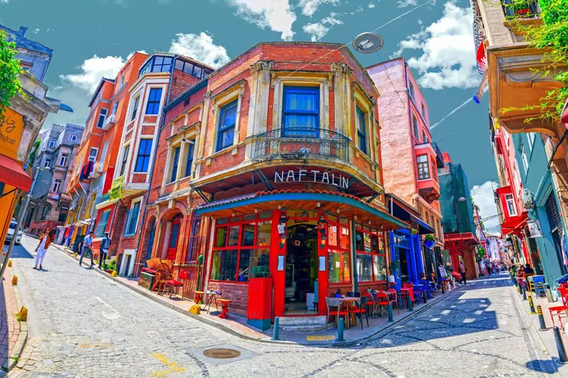 یک خیابان سنگفرش و شیب&zwnj;دار در محله تاریخی بالات استانبول، با خانه&zwnj;های رنگارنگ و کافه&zwnj;های قدیمی