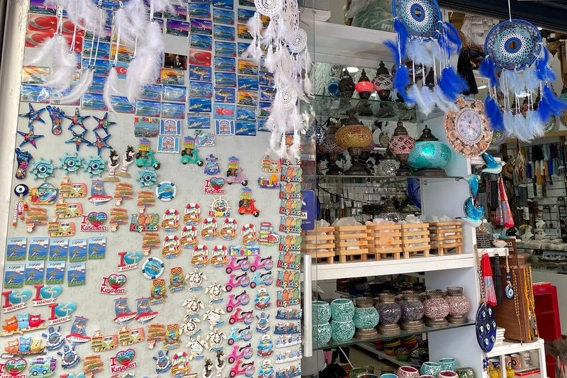 بازار حاجیوات کوش آداسی برای اولین بار در سال ۱۹۶۸ تاسیس شد. از همان سالها سعی کرده تا با داشتن غرفههای رنگارنگ از صنایع دستی و سوغاتیهای کوش آداسی مورد توجه اغلب مسافران داخلی و خارجی قرار بگیرد. قیمتها در این بازار کاملا مناسب بوده و علاوه بر خرید میتوانید در آن با فروشندگان صمیمی و خونگرم منطقه به گفت و گو بپردازید و لحظات خوبی را برای خود رقم بزنید.